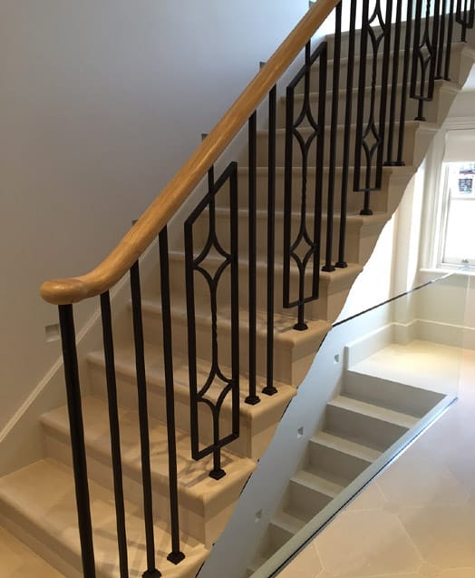 Elegant, continuous steel staircase balustrade with oak handrails Elegant, continuous steel staircase balustrade with oak handrails